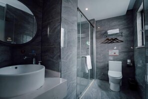 A modern bathroom with a round sink, a glass-enclosed shower, and a toilet. - Zheng'an Manfei Hotel (Guitar Culture Squaie Branch) (Zheng'an)