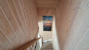 A wooden interior with a view of a sunset through a window. - Villa Mar Baabe (Ostseebad Baabe)