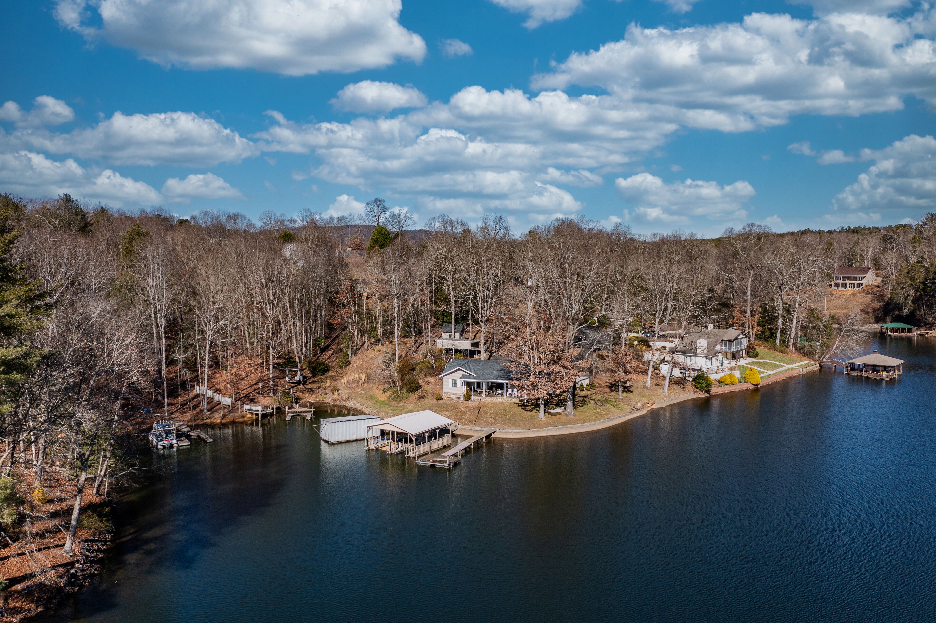 Une propriété au bord du lac, comprenant un quai, une maison et un belvédère.