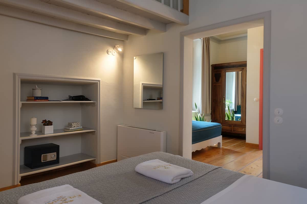 Ein Schlafzimmer mit Bett, Nachttischen, einem Heizkörper und einem Kleiderschrank.