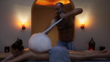 Experience a rejuvenating massage in a serene space with a comfortable bed and soothing ambiance.