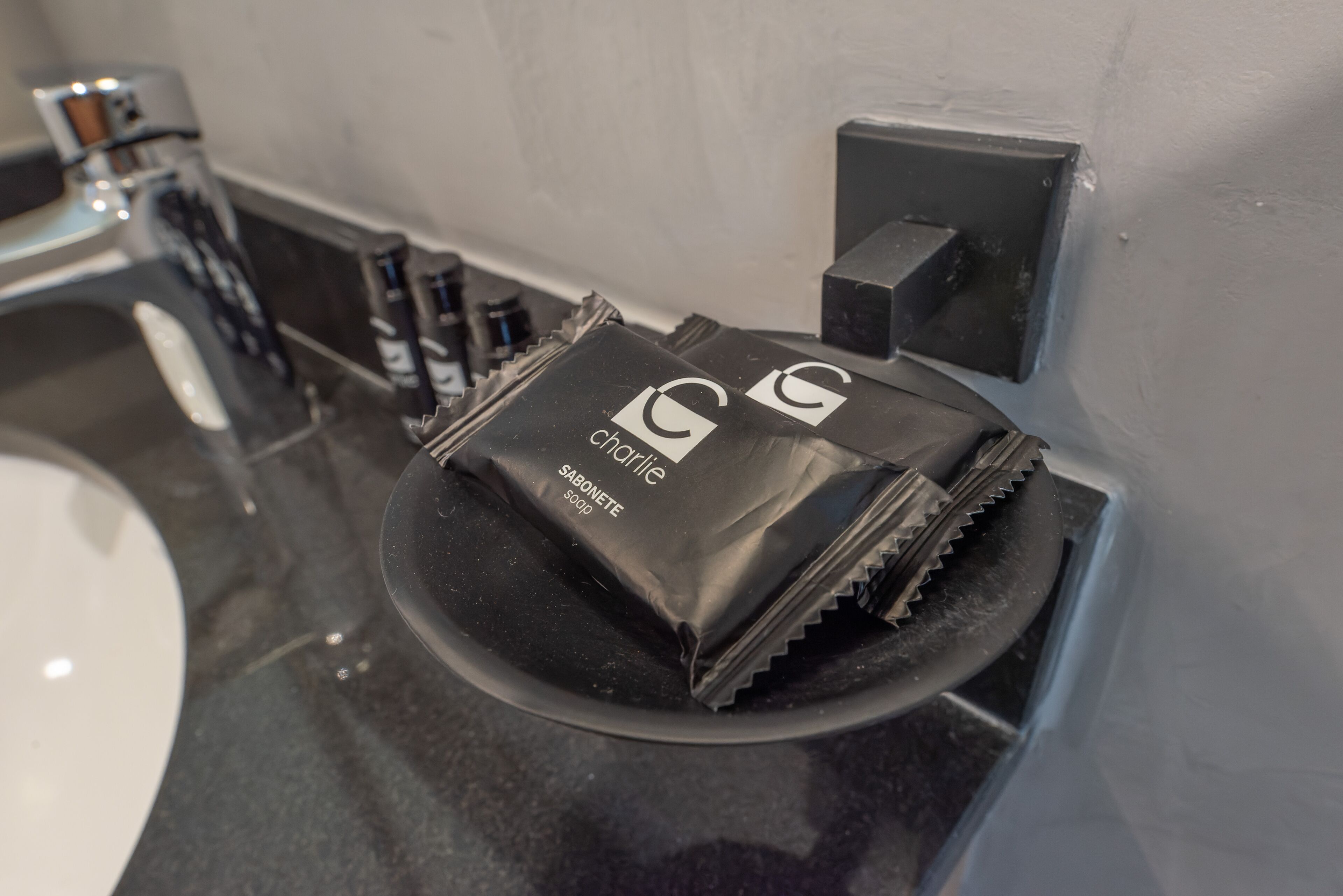 Un bagno con un piano lavabo nero, un dispenser di sapone e una saponetta etichettata 'Cedarville'.