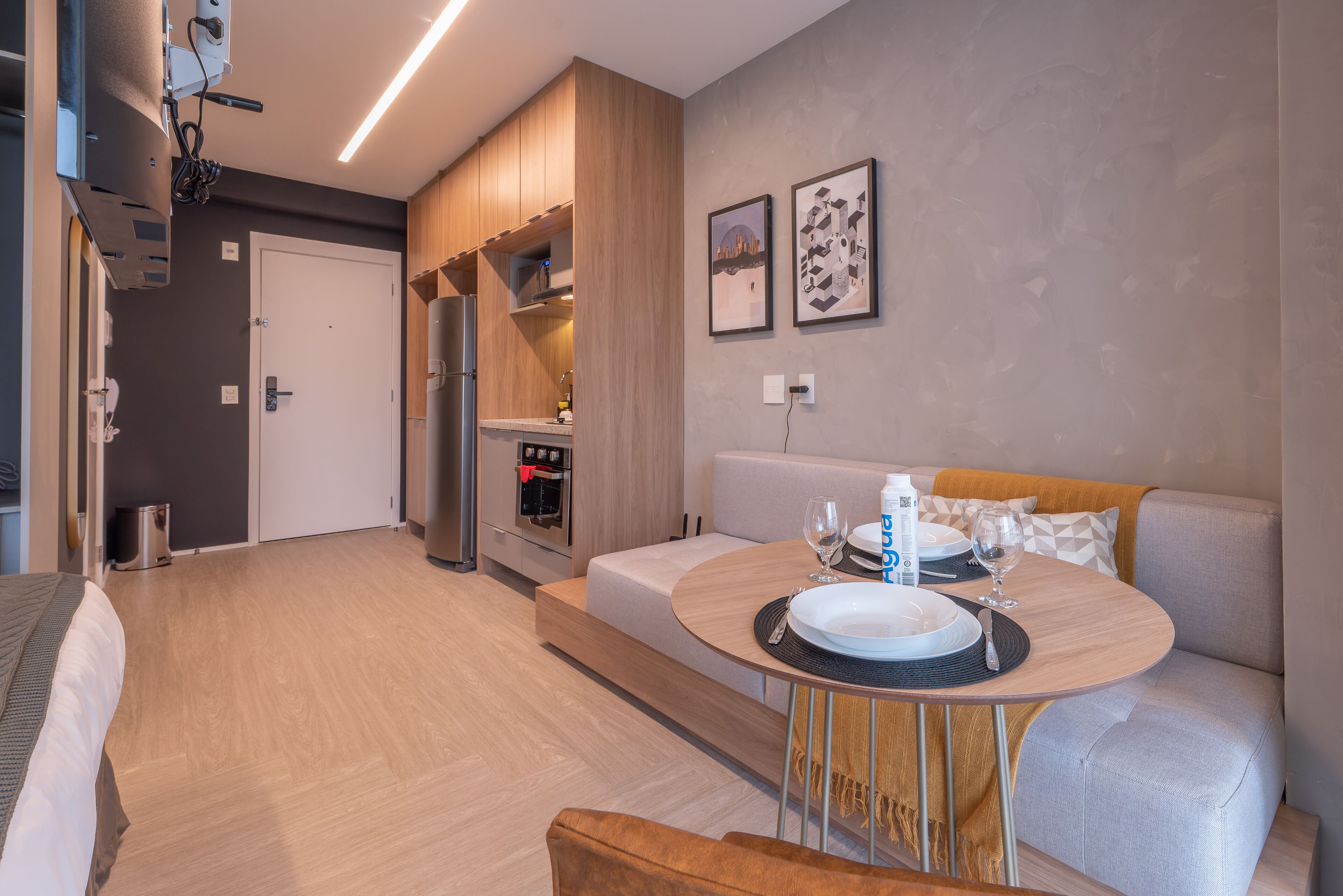 Una cocina moderna con electrodomésticos integrados, una zona de comedor con una mesa redonda y un sofá.