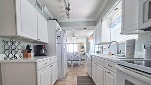 A kitchen with white cabinets, a coffee maker, and a sink. - Oceanfront Corner Three Bedroom Unit - Crescent Sands L5 (North Myrtle Beach)