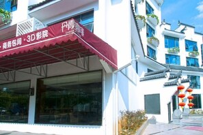 Un bâtiment abritant une salle de cinéma en 3D et un restaurant avec un auvent rouge.