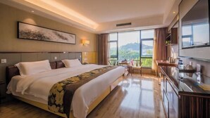 Habitación de hotel moderna con una cama grande, un escritorio y vistas al exterior.