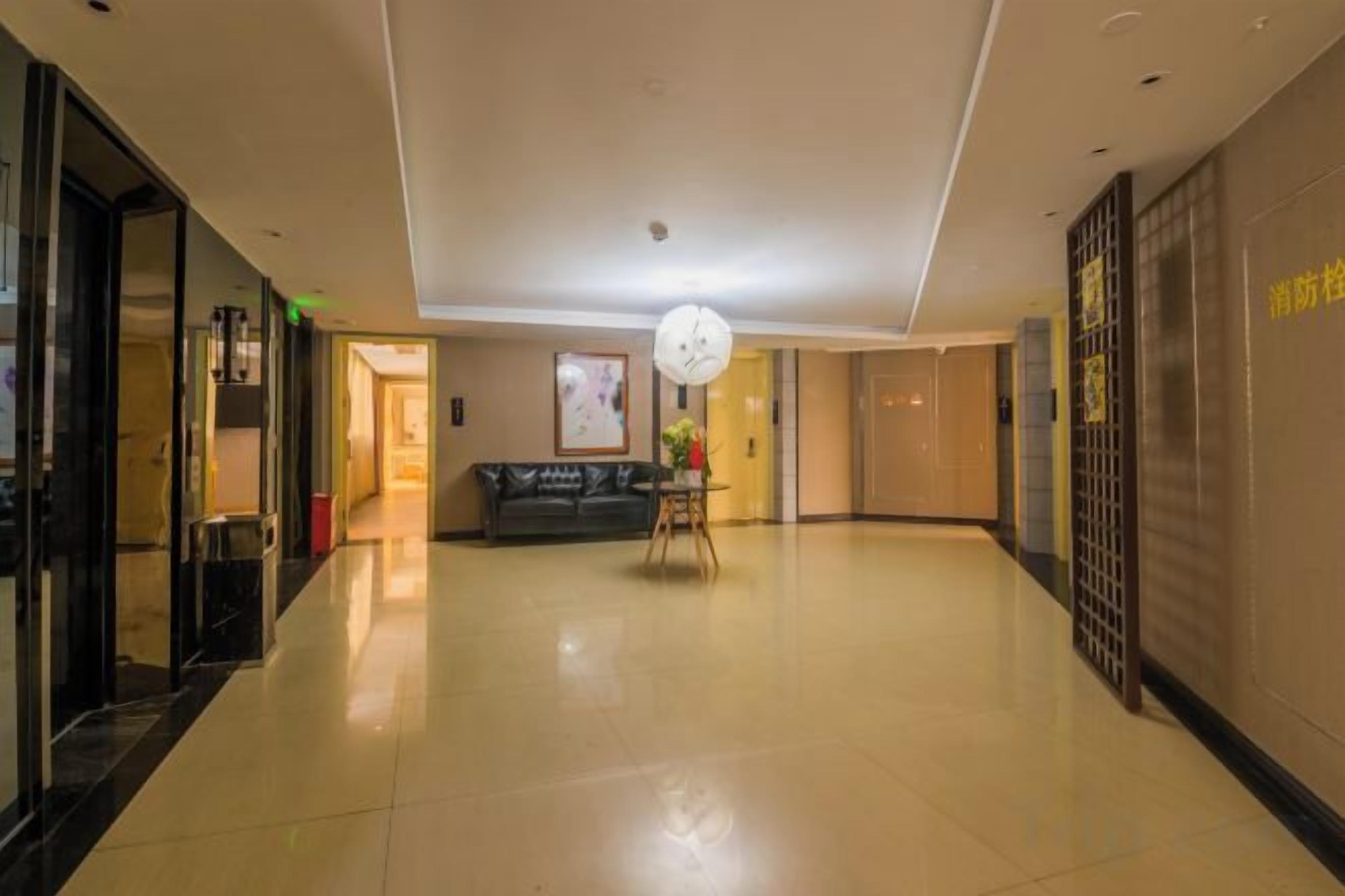 A hotel lobby with a reception desk, a clock, and a sofa.