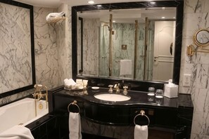 Un baño moderno con un espejo grande, una bañera, un lavabo y una zona de ducha.
