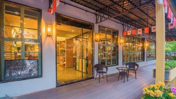 Un restaurante con amplios ventanales, una zona de estar al aire libre cubierta y una entrada acogedora.