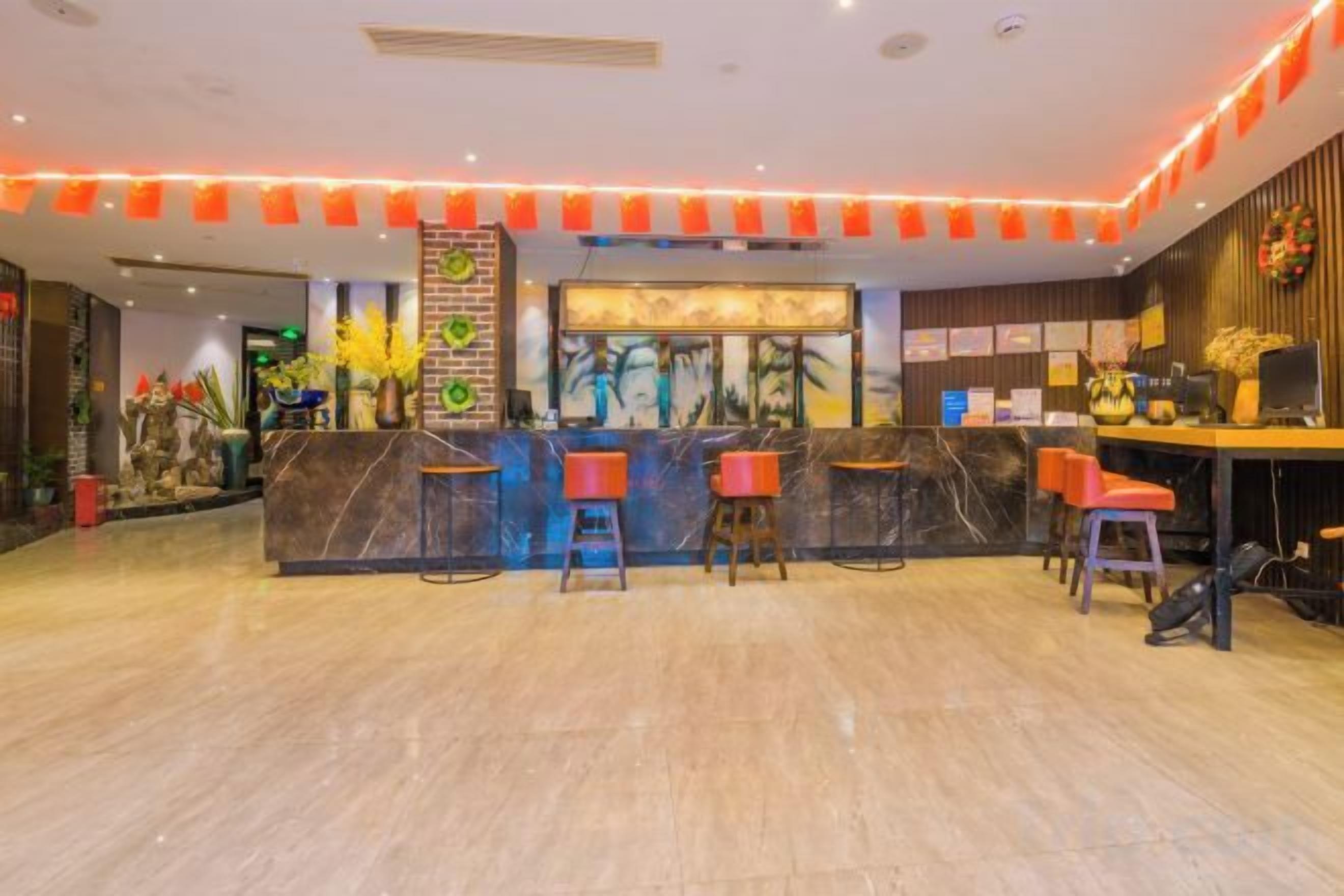 Un'area reception di un hotel con un bancone in marmo, diversi sgabelli da bar e un design moderno.