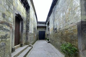 Une ruelle étroite aux murs de pierre, avec une porte au fond.