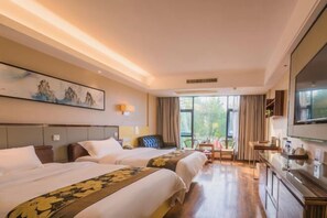 Una habitación de hotel con dos camas, un escritorio, una silla y un televisor.