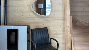 A room with a wooden ceiling, a black leather chair, a white cabinet, and a round mirror on the wall. - Chalet "DIANA", at the foot of the ski slopes. Pets allowed  (Gérardmer)