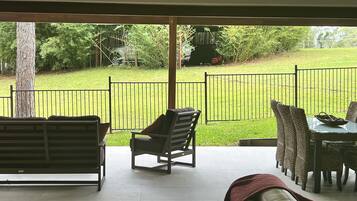 Enjoy dining or relaxing in this sheltered outdoor space with a beautiful lawn view.