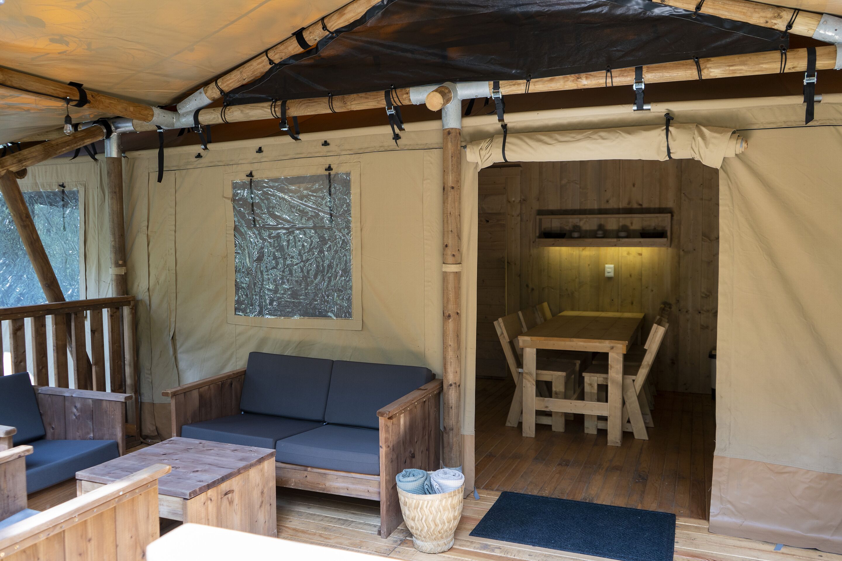 Un interior acogedor con un sofá de madera, una mesa de comedor y una ventana con vistas.