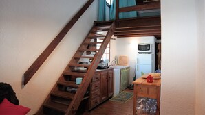 Une cuisine avec un escalier en bois, un four à micro-ondes et un évier.