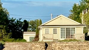 A house with a stone retaining wall, a garage, and a large window.