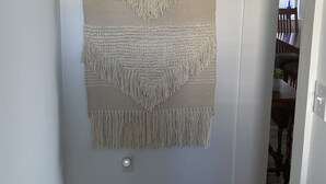 A wall with a 'Welcome' sign and a macramé wall hanging.