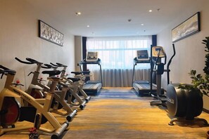 A gym with stationary bikes, treadmills, and a rowing machine.