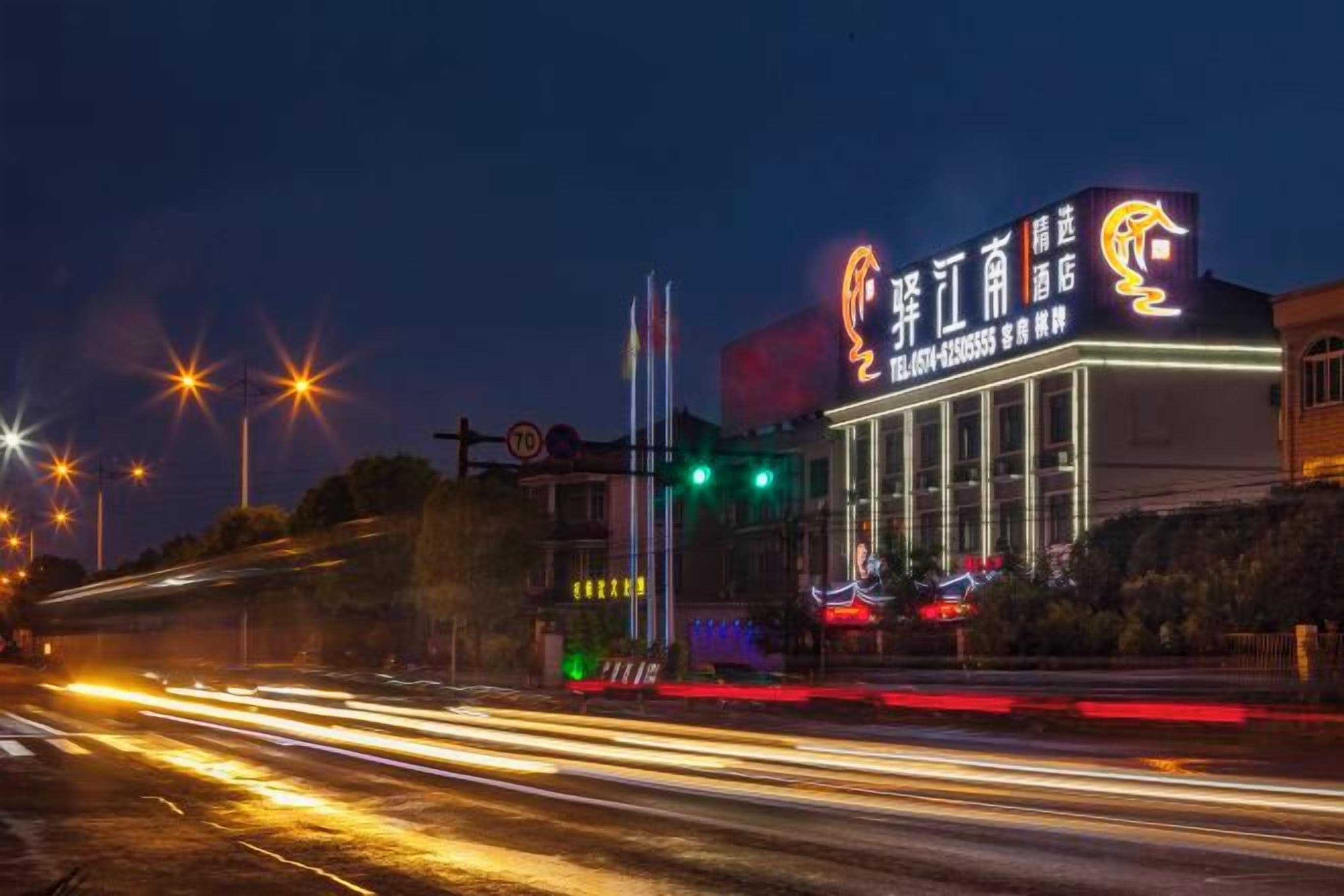Un edificio con señalización iluminada y una estructura vertical destacada.