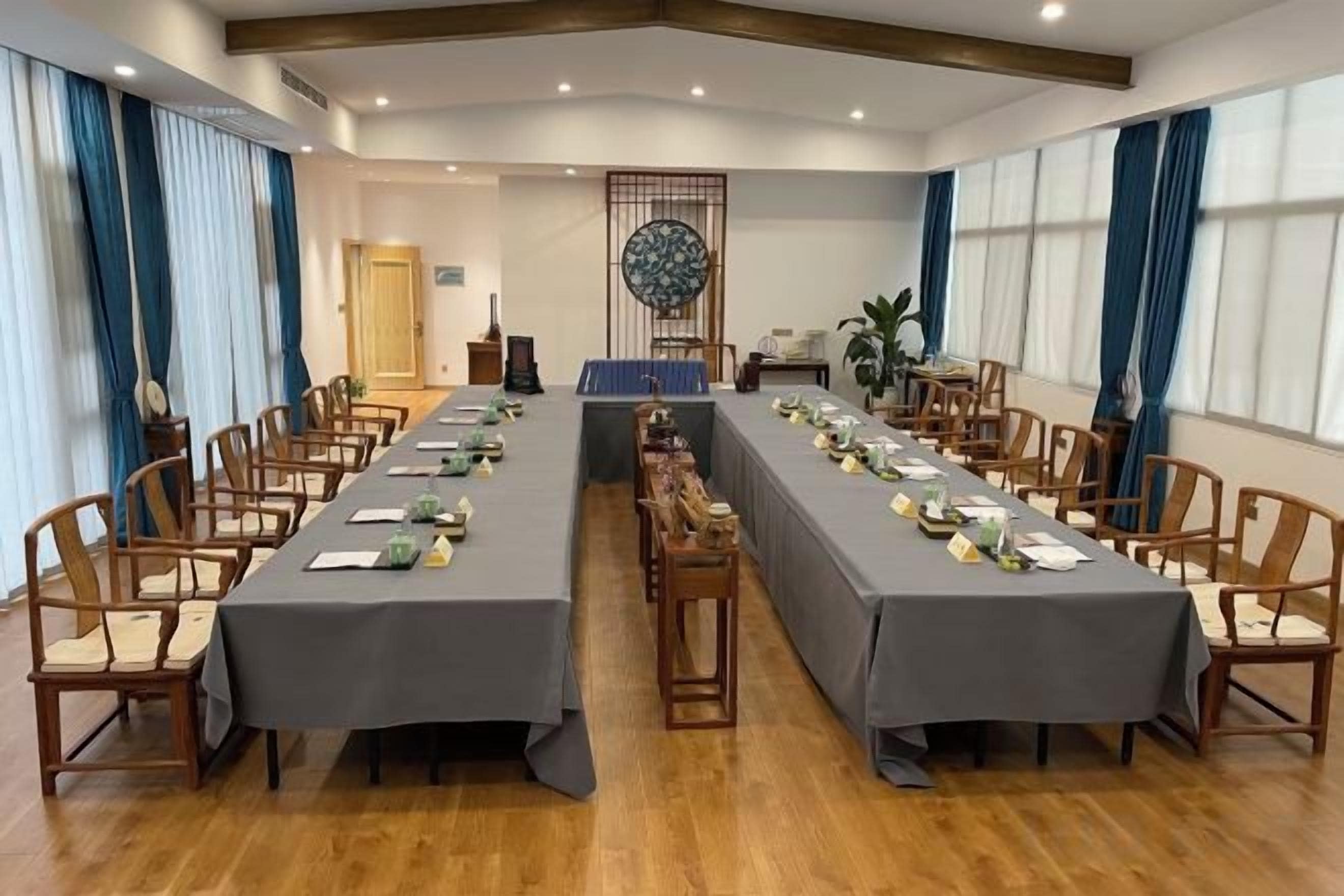 A conference room with a long table, chairs, and a decorative wall piece.