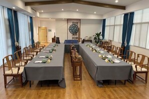 A conference room with a long table, chairs, and a decorative wall piece. - Yijiangnan Selected Hotel (Yuyao)