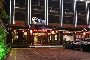 A traditional building with a sign that reads 'Yingjiang' and a parking lot with cars. - Yijiangnan Selected Hotel (Yuyao)
