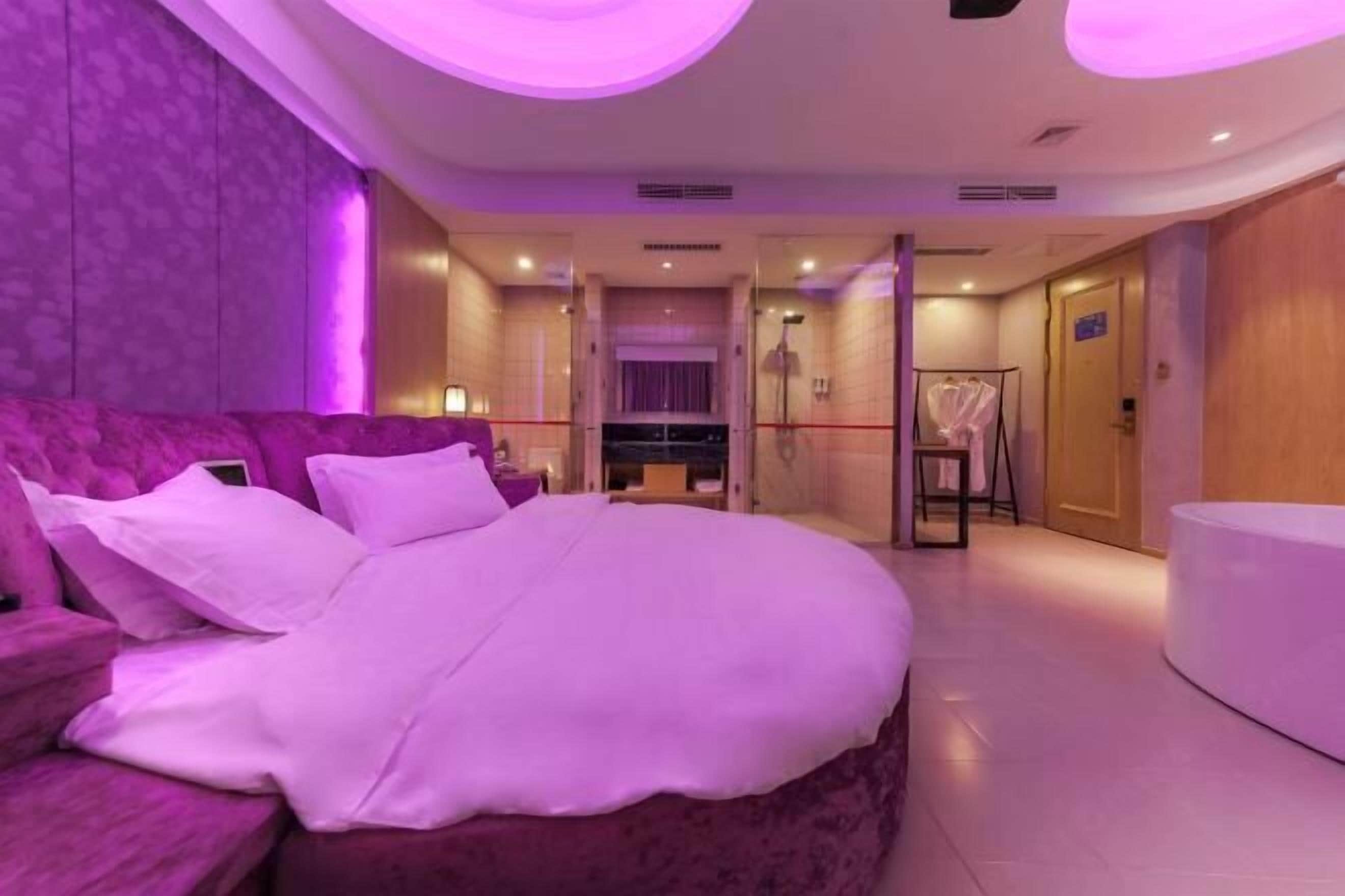 Una camera da letto moderna con un letto grande, una toeletta e un cabina armadio.