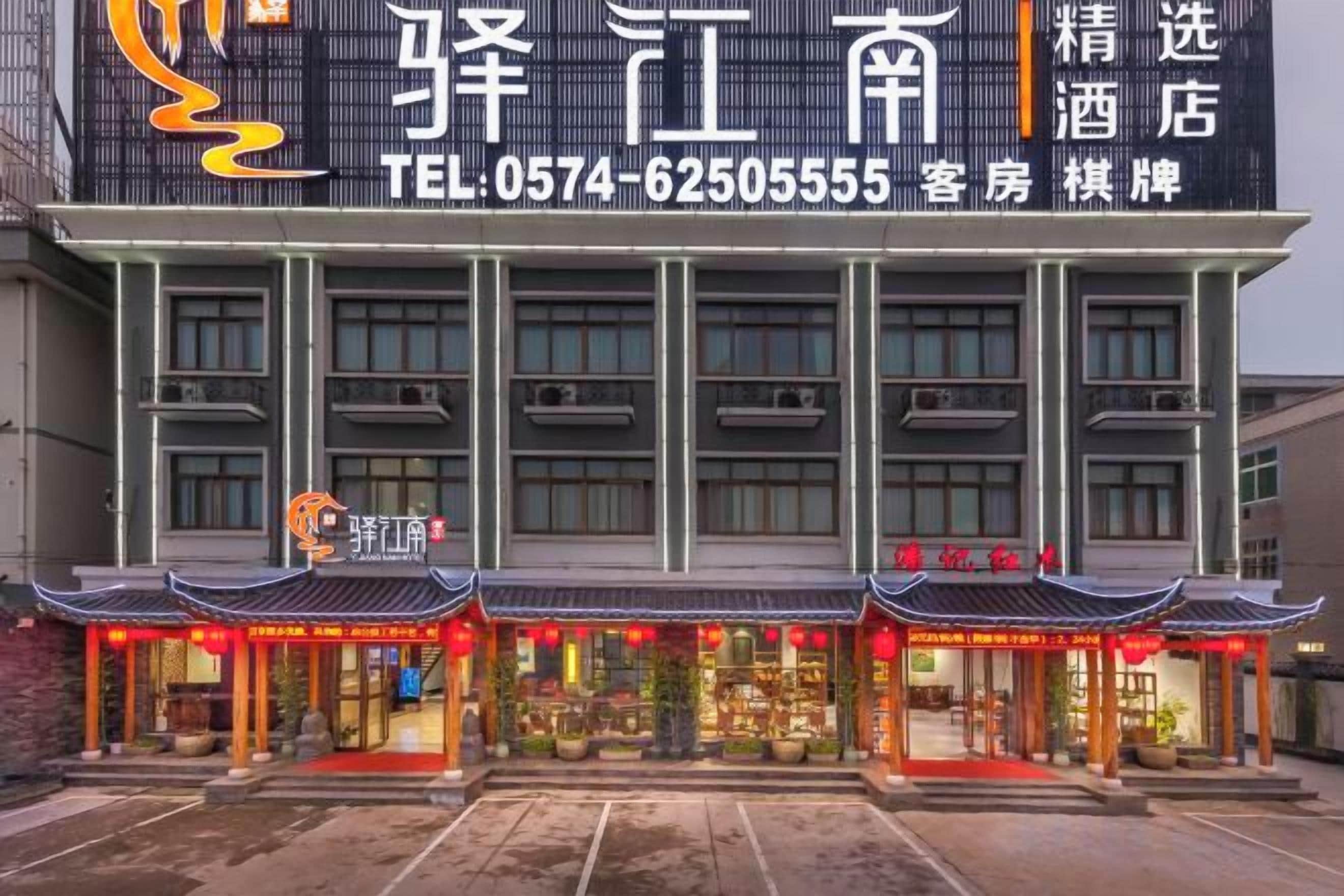 Un hotel de estilo arquitectónico chino tradicional, con un gran letrero con información de contacto y una fachada moderna.