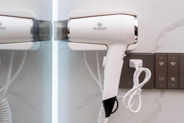 A hair dryer mounted on a wall with a control panel and a power cord.