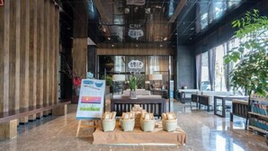 Un interior moderno con un mostrador de recepción, zona de estar y una exhibición de cestas tejidas.