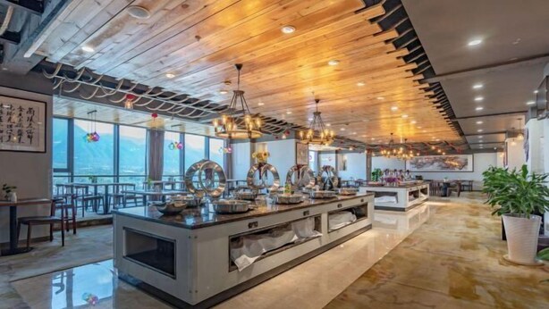 Una cocina moderna con una isla central, ventanas amplias y techo de madera.