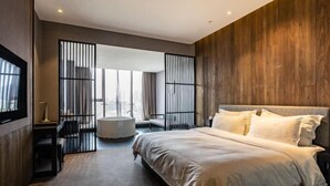 Un dormitorio moderno con una cama grande, un escritorio y una bañera.