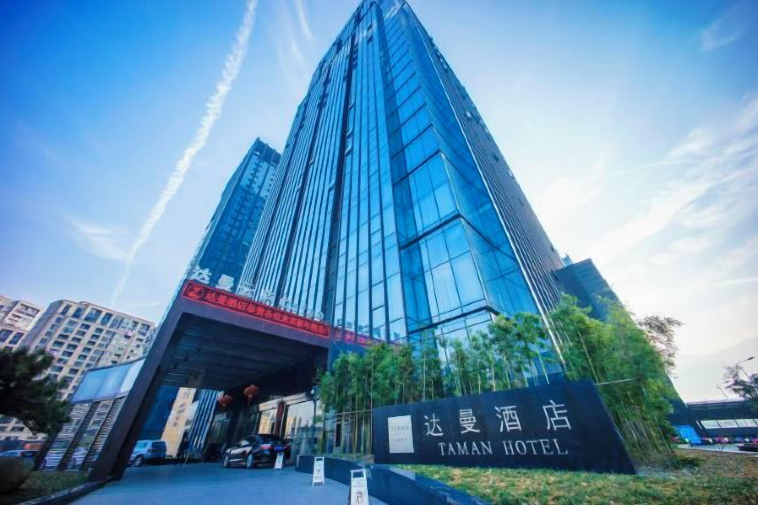 Un moderno edificio de hotel con una entrada destacada y señalización.