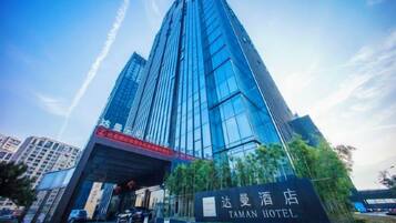 Un moderno edificio de hotel con una entrada destacada y señalización.