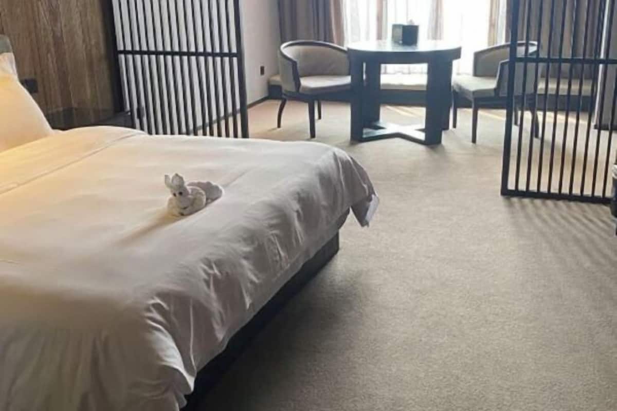 A hotel room with a bed, a small table, and chairs.