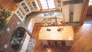 A kitchen with a central island, wooden cabinets, and a hanging pot rack.