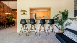 Eine moderne Küche mit Holzausstattung, einem integrierten Kühlschrank und einer Bar mit Sitzgelegenheiten.