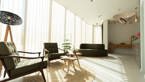 A modern living room with a sofa, armchair, and a small table. - Grapple Hotel (Carrazeda de Ansiaes)
