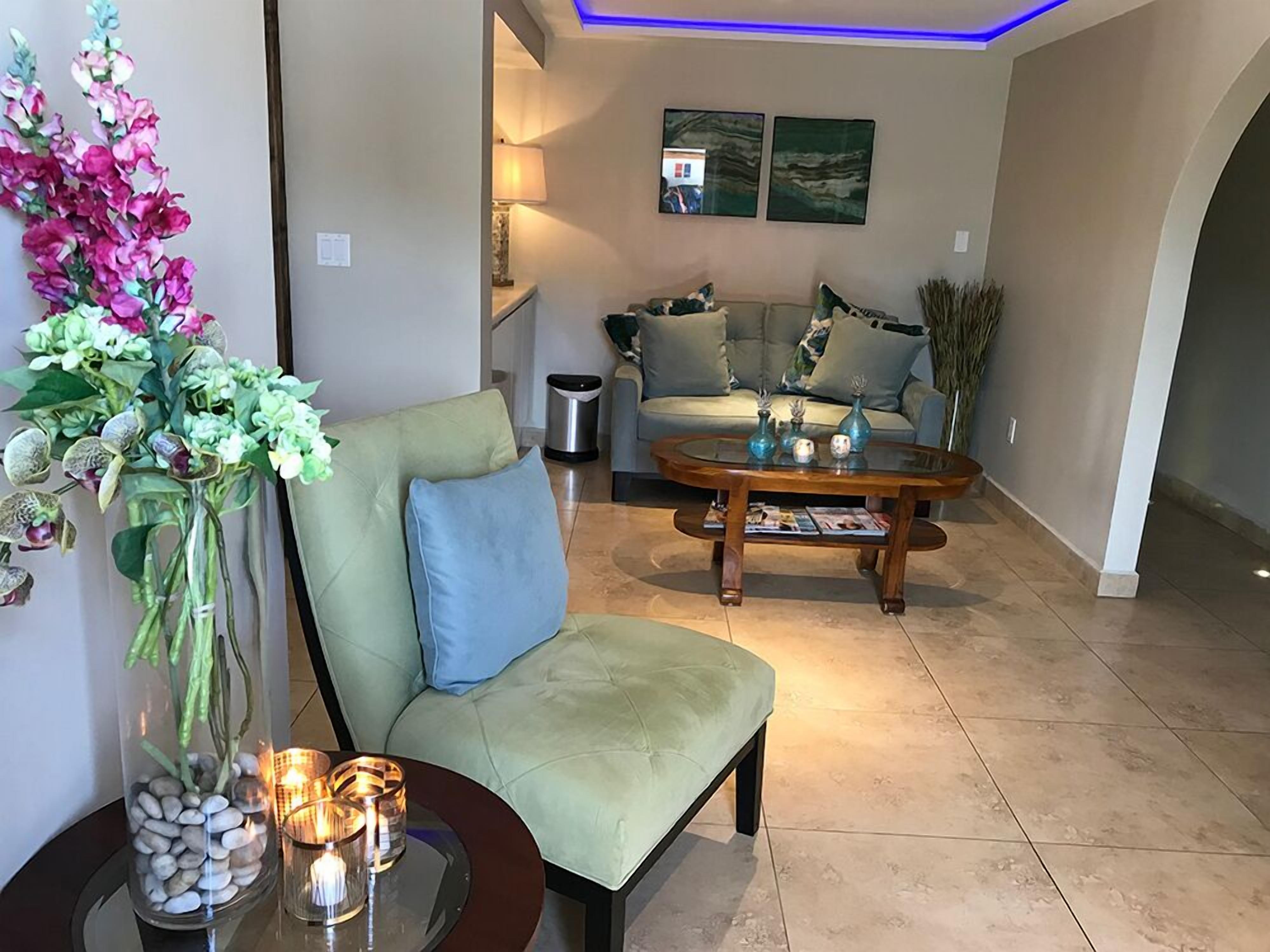 Un salón con un sofá, una mesa de centro y un jarrón decorativo con flores.