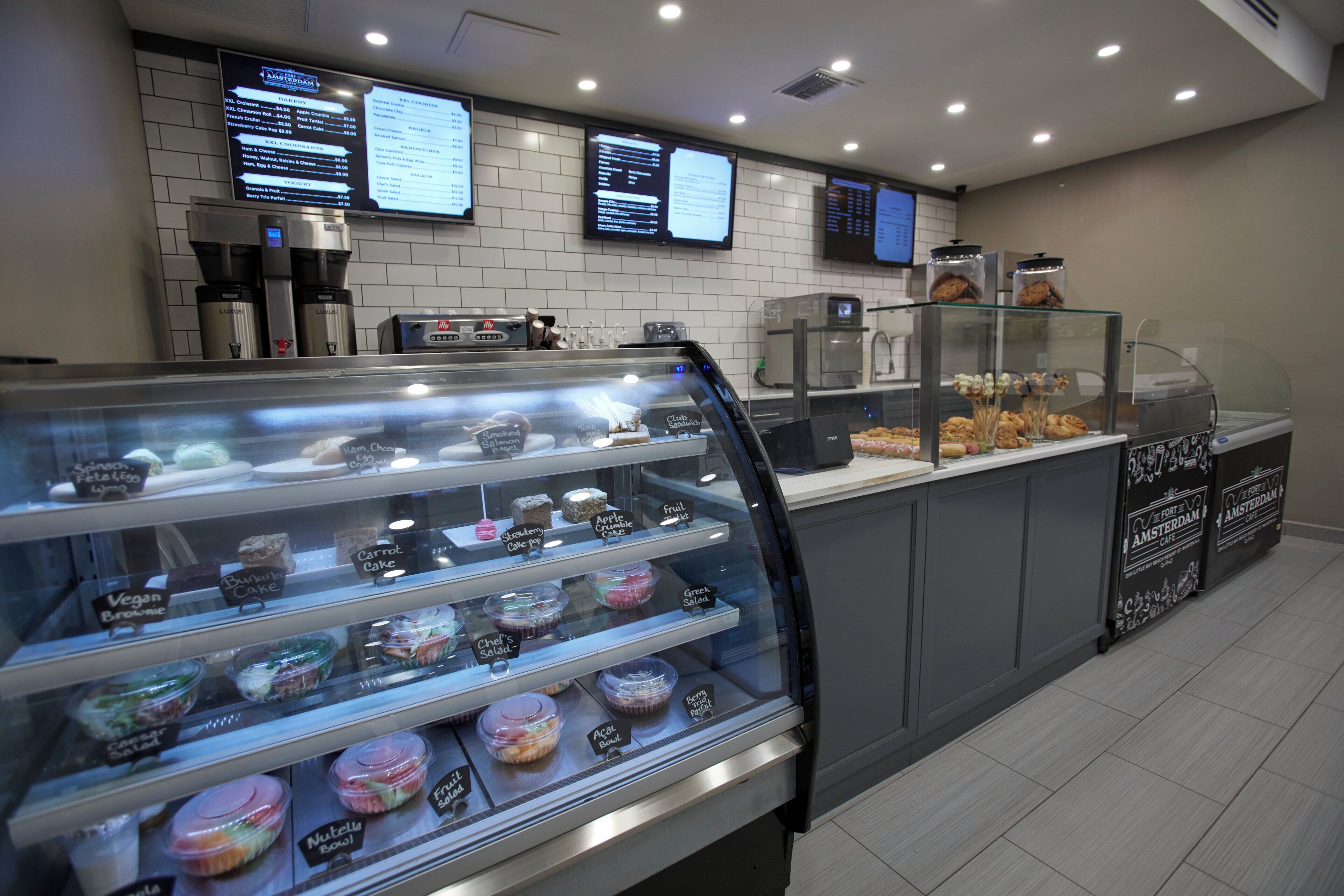 A bakery display case with various baked goods and a coffee machine.