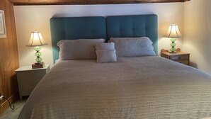 A bed with a teal headboard, two bedside lamps, and a white comforter. - The Sea Witch-Beautiful inlet views just one block from beach! (Murrells Inlet)