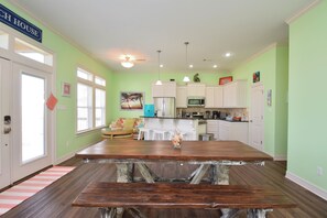 Eine geräumige Küche mit einer großen Holztheke, weißen Schränken und einer Wand in Türkis.