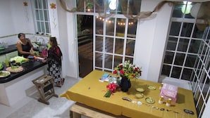 A dining area with a yellow tablecloth, a vase of flowers, and plates with cake decorations.