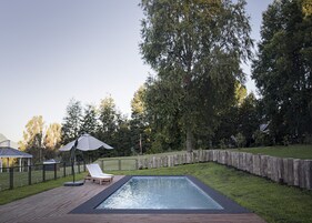 Una piscina al aire libre de temporada, sillones reclinables de piscina
