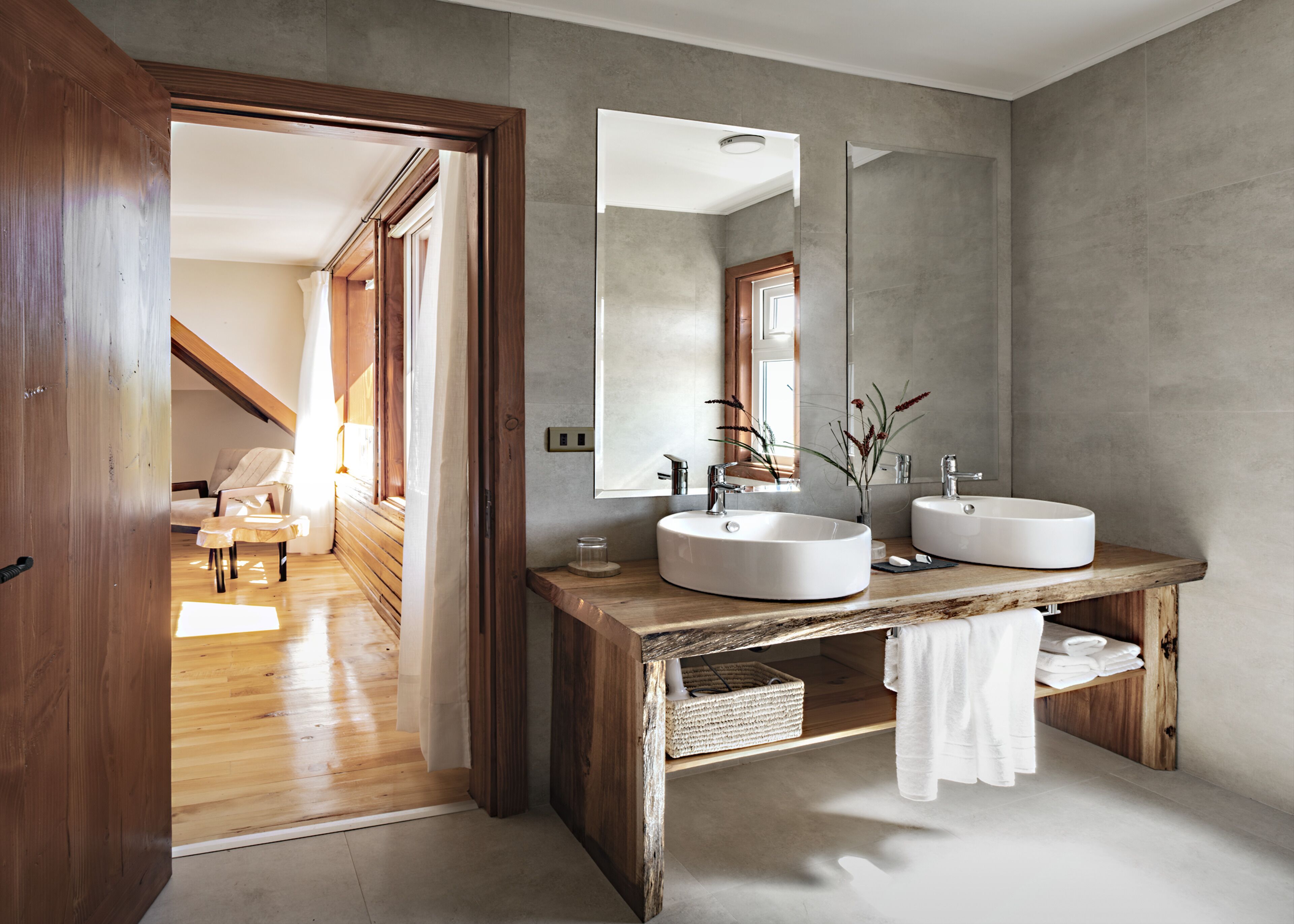 Une salle de bain moderne avec deux lavabos, un grand miroir et un meuble-lavabo en bois.