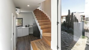 Una cocina moderna con una escalera de madera que conduce a un vidrio.