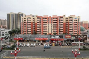 A multi-story residential building with a parking lot in front. - Vienna Hotel (Dongguan Dalang) (Dongguan)