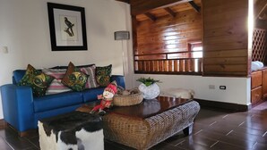 Un accogliente soggiorno con un divano blu, un tavolino in legno e un pupazzo di neve decorativo.