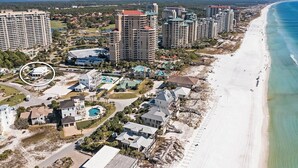Eine Luftaufnahme einer Küstenlandschaft mit Hochhäusern, Strandimmobilien und einem tiefblauen Meer.